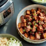 Cubed BBQ tempeh glazed in sauce, served in a bowl with garnish, cooked in an Instant Pot.